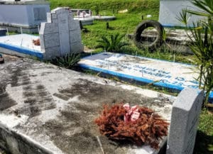 A discarded tire leans against a grave plot in St. Thomas’ Western Cemetery. (Source photo by Bethaney Lee)