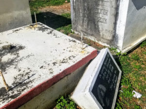 A fallen tombstone is wedged in between two graves sites making it difficult to pass. (Source photo by Bethaney Lee)