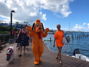 Krewe de Croix members John McCoy, dressed in a bright orange dog costume, and Val Stiles lead Krewe de Barkus participants on the boardwalk. (Source photo by Susan Ellis)
