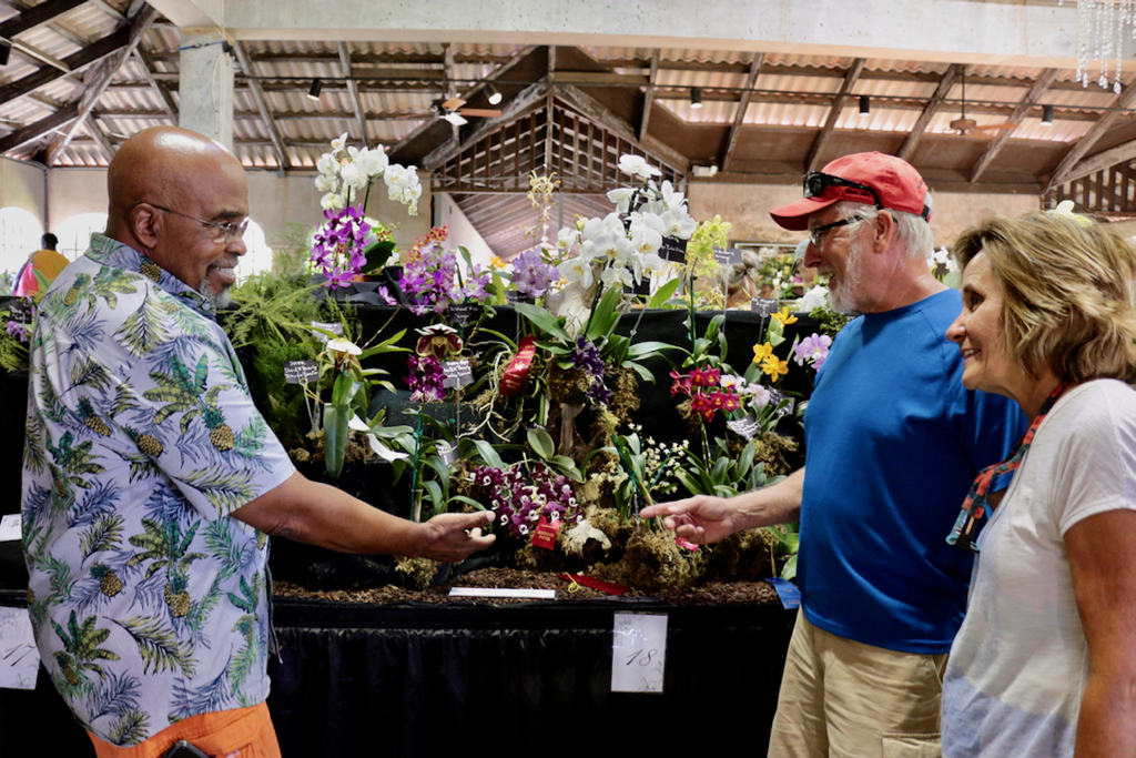 Luther Edwards of The St. Croix Orchid Society assists Paul and Denise Langevin of New Jersey with questions. (Source photo by Linda Morland)