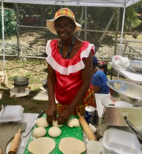 Ecelma Sprauve prepares dumbread for baking over coal made by Julian Frett. (Source photo by Amy Roberts)