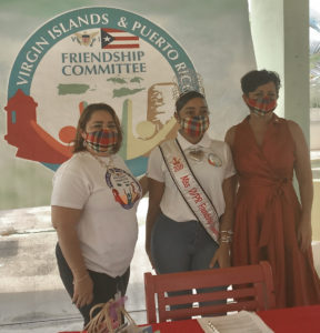 From left, Maria Colon-Clarke, Miss VI-PR Friendship 2019 Rosa-Leea Clarke, and DHS Commissioner Kimberly Causey-Gomez make a presentation to senior caregivers on Friday. (Source photo by Elisa McKay)