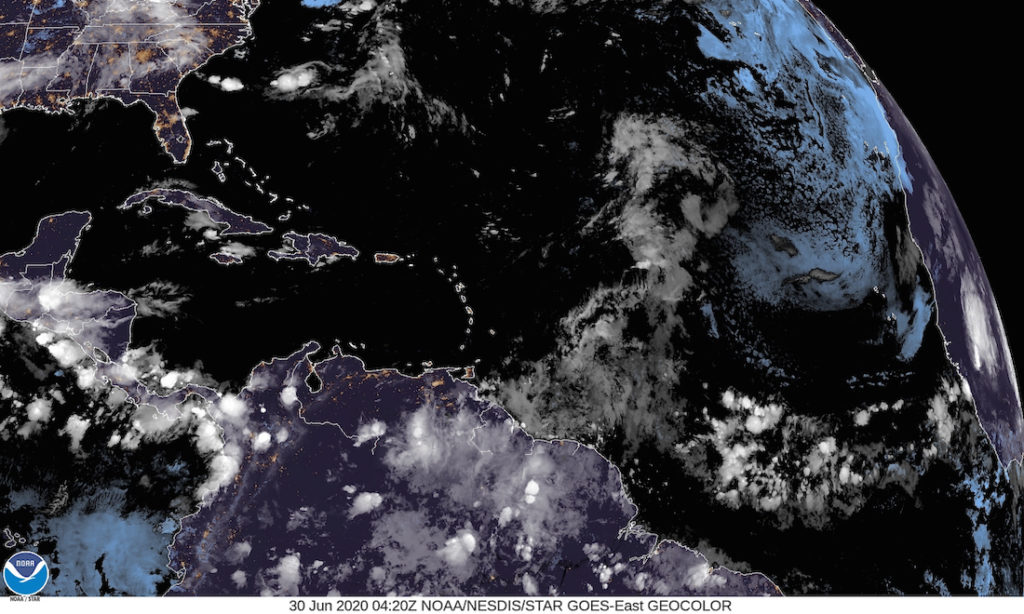 A satellite photo taken at 12:20 a.m. shows a disorganized tropical wave east of the Caribbean, and another system off the coast of North Carolina and heading out into the Atlantic. (NOAA photo)