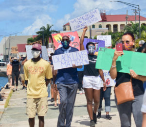 During Saturday's protest march, UVI President David Hall attends the March and holds up a sign that reads "Black Lives Matter." (Source photo by Kyle Murphy)
