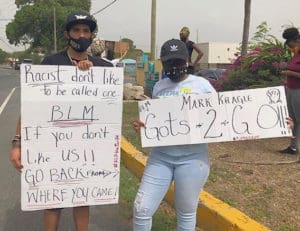 Protestor spread their message in front of the WAPA office. (Source photo by Diana Dias)