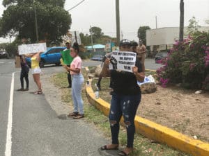 Protestor signal to passing cars.(Source photo by Elis McKay)