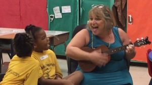 Kristen Carmichael-Bowers sings with first graders at JESS in 2018. (Photo by William Steltzer)