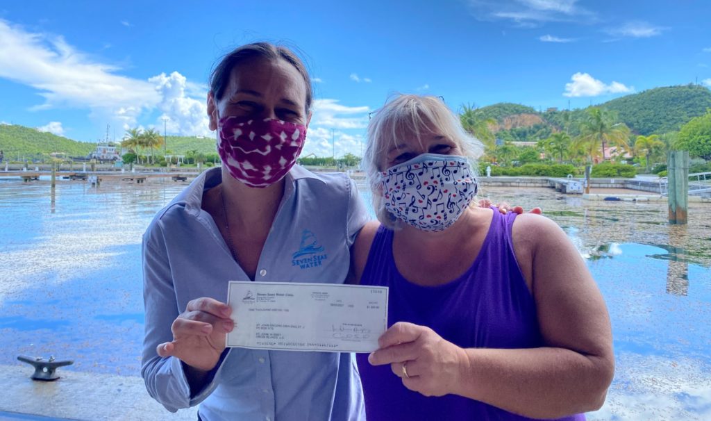 Catherine Wilson of Seven Seas Waters presents a check to Kristen Carmichael-Bowers in support of Sing St. John. (Photo by Seven Seas Water)