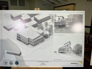 A signboard shows Springline Architects’ drawings of the proposed clinic’s exterior. (Source photo by Amy H. Roberts)