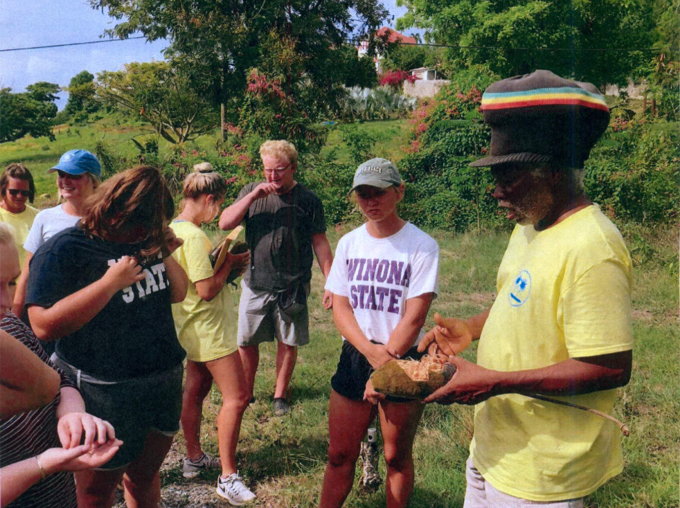 Olasee Davis, a bushman, explains the nutritional value of the baobab fruit to students from Winona State University. (Photo by Winona State University) 
