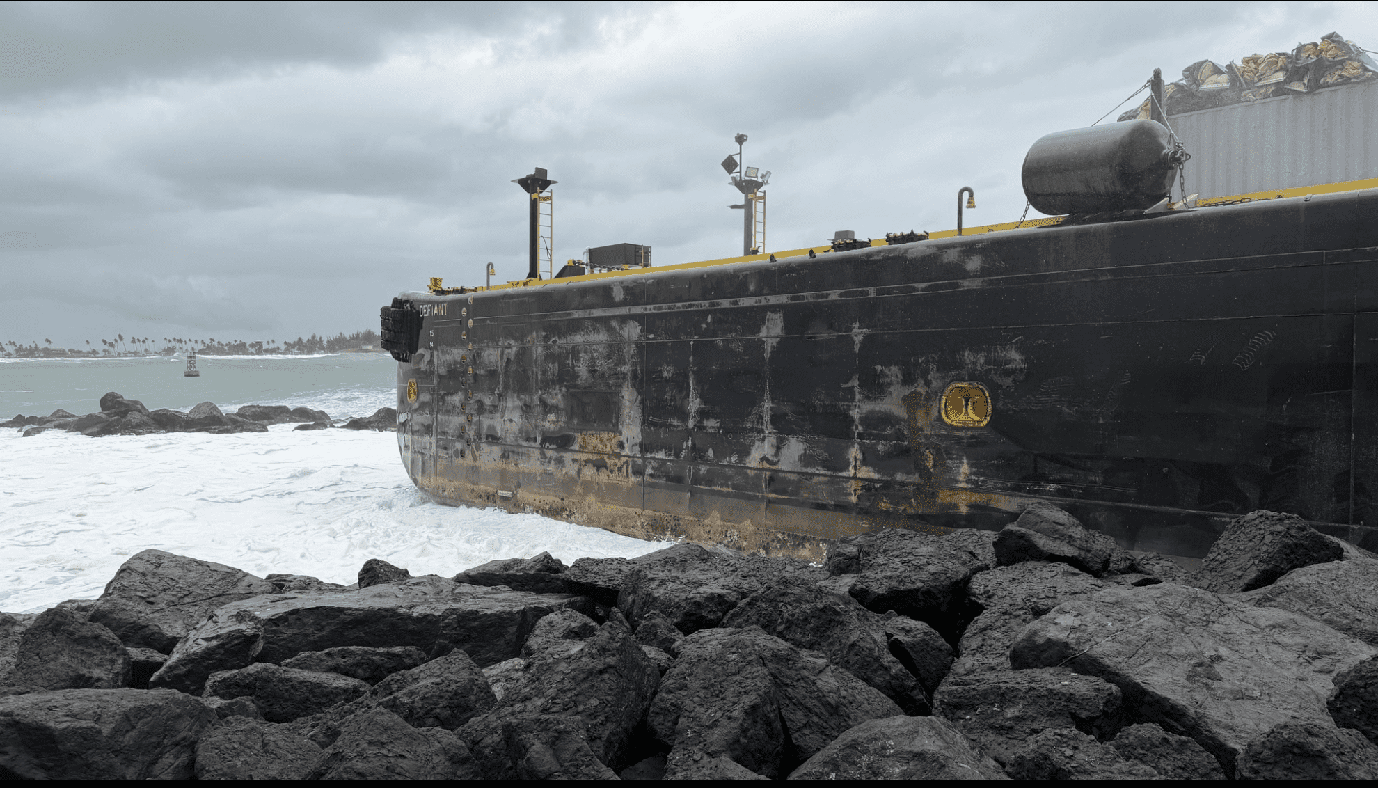 The fuel barge Defiant sits on the rocks at the entrance to San Juan Harbor after running aground on Monday. (Photo courtesy Coast Guard)