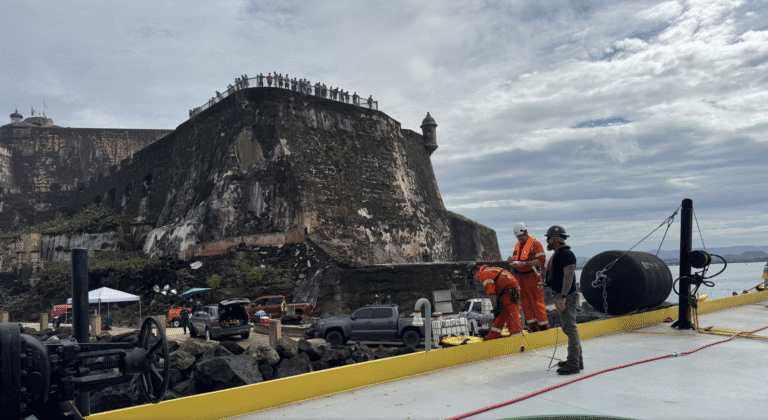 Workers remove fuel from the barge Defiant on Thursday after it grounded off el San Felipe del Morro Castle in San Juan, Puerto Rico. (Photo courtesy Coast Guard)