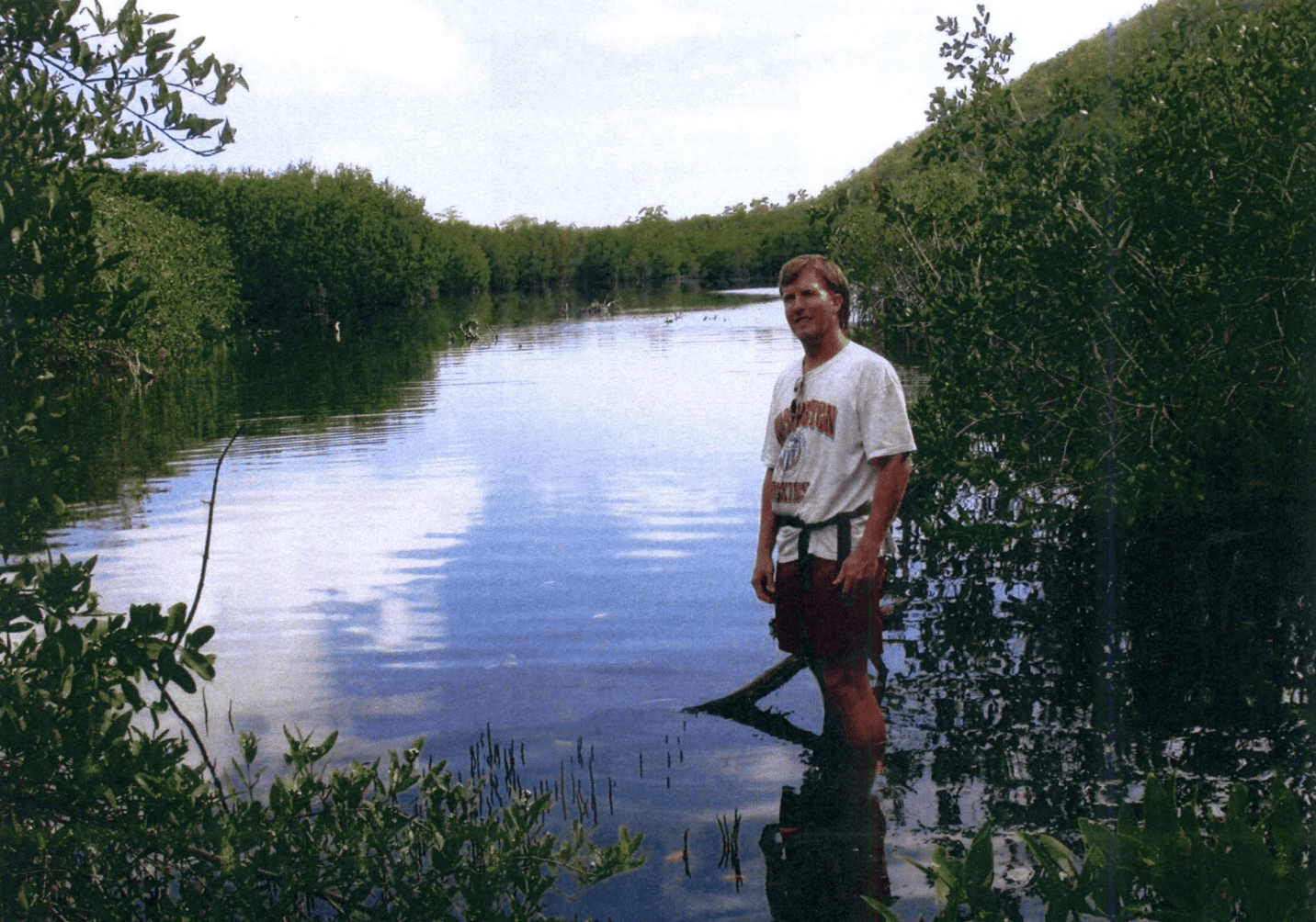 UVI student standing in Perseverance Bay, known locally as "Flamingo Pond" surrounding by the mangrove forest.